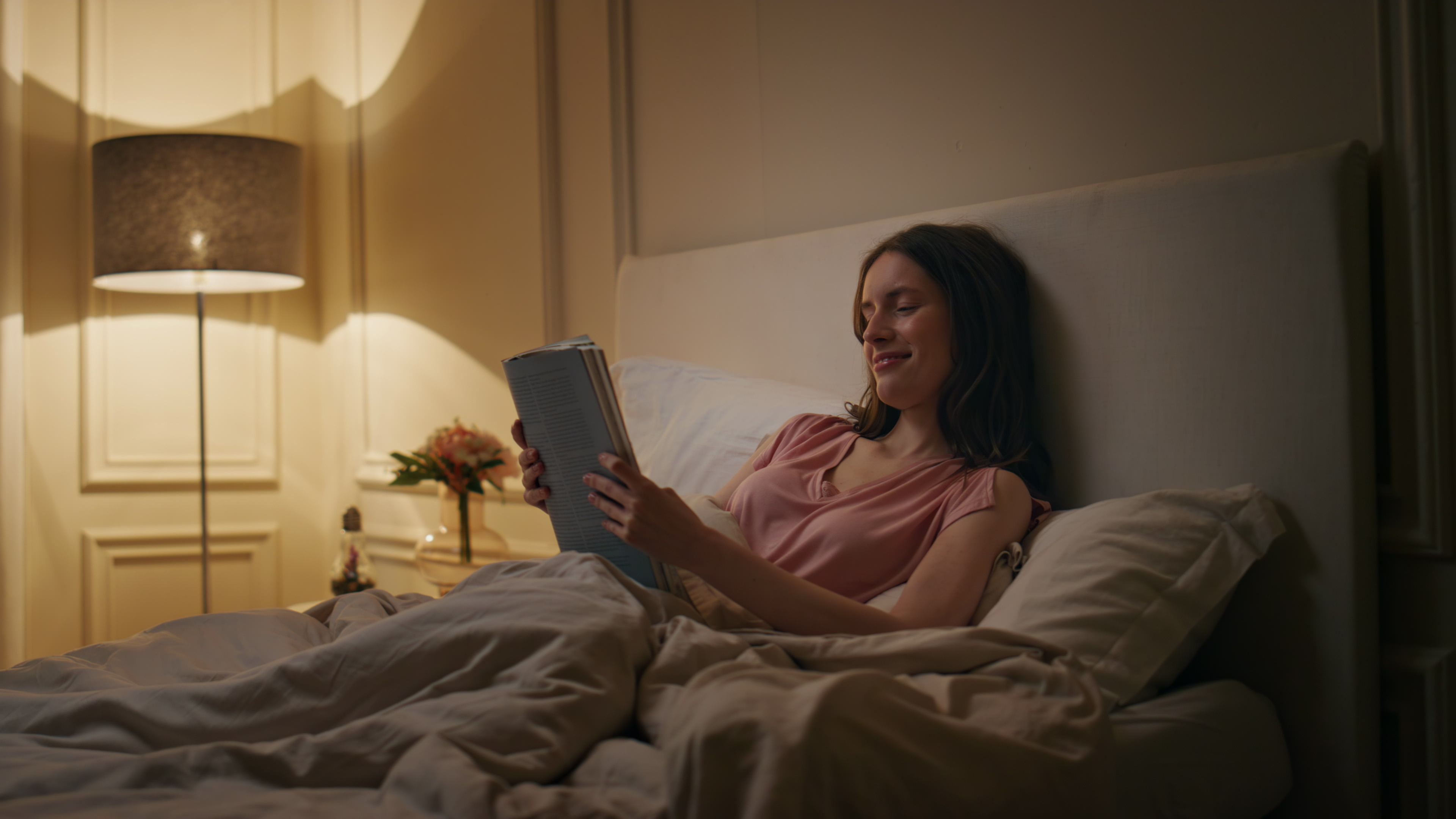 Woman sitting in bed reading a book