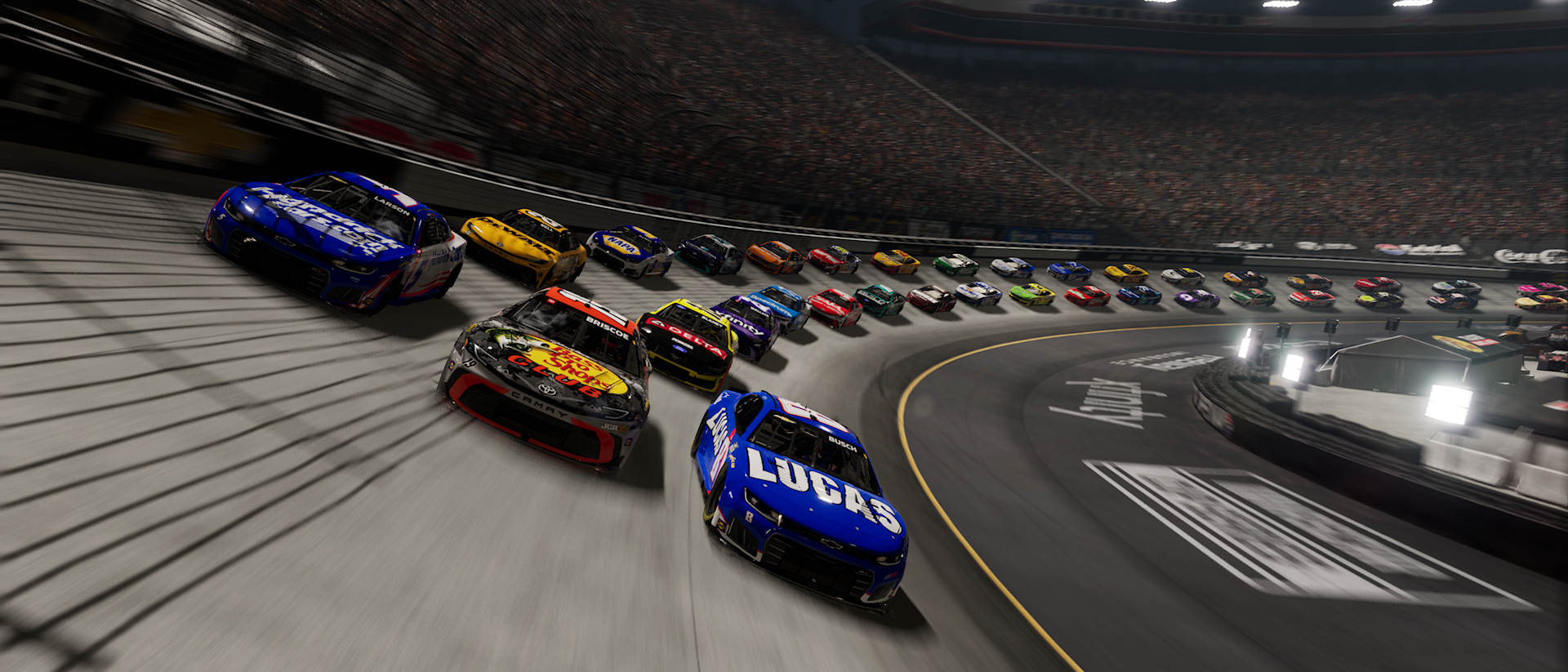 A screenshot from NASCAR 26 at the Bristol Night Race with Kyle Larson, Chase Briscoe, and Kyle Busch running together.