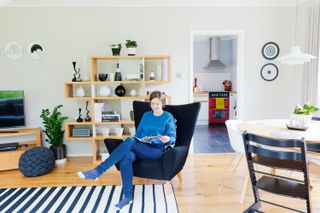 Neutral living room with striped monochrome rug and wooden shelves