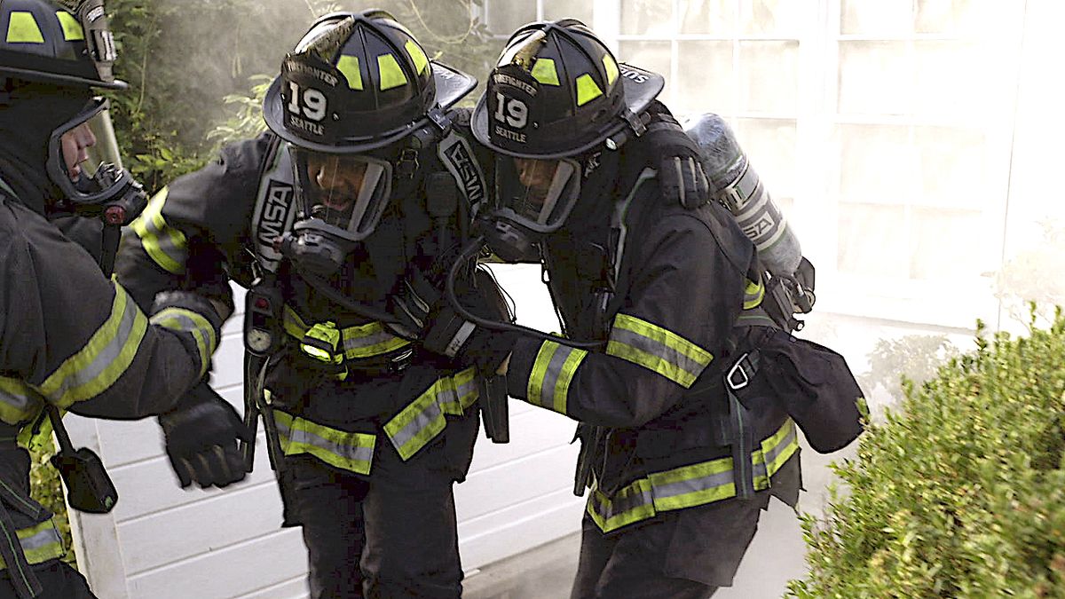 Unidentified firefighters from Station 19 lean on each other at an emergency.