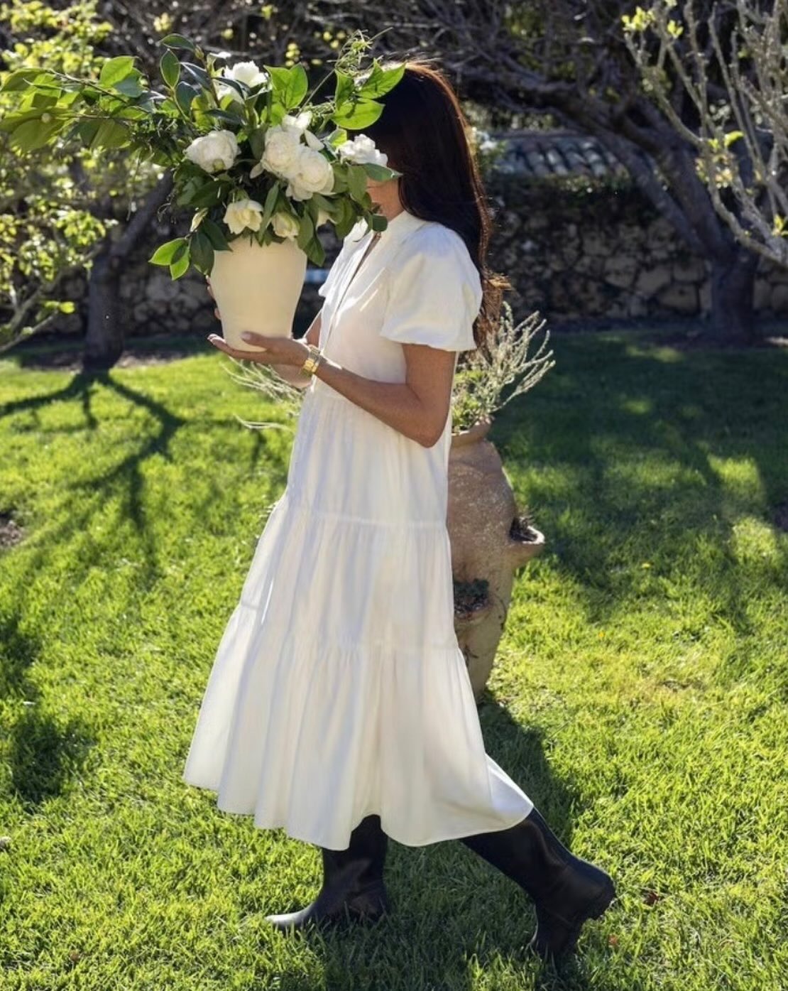 Meghan Markle wears a white dress and rain boots