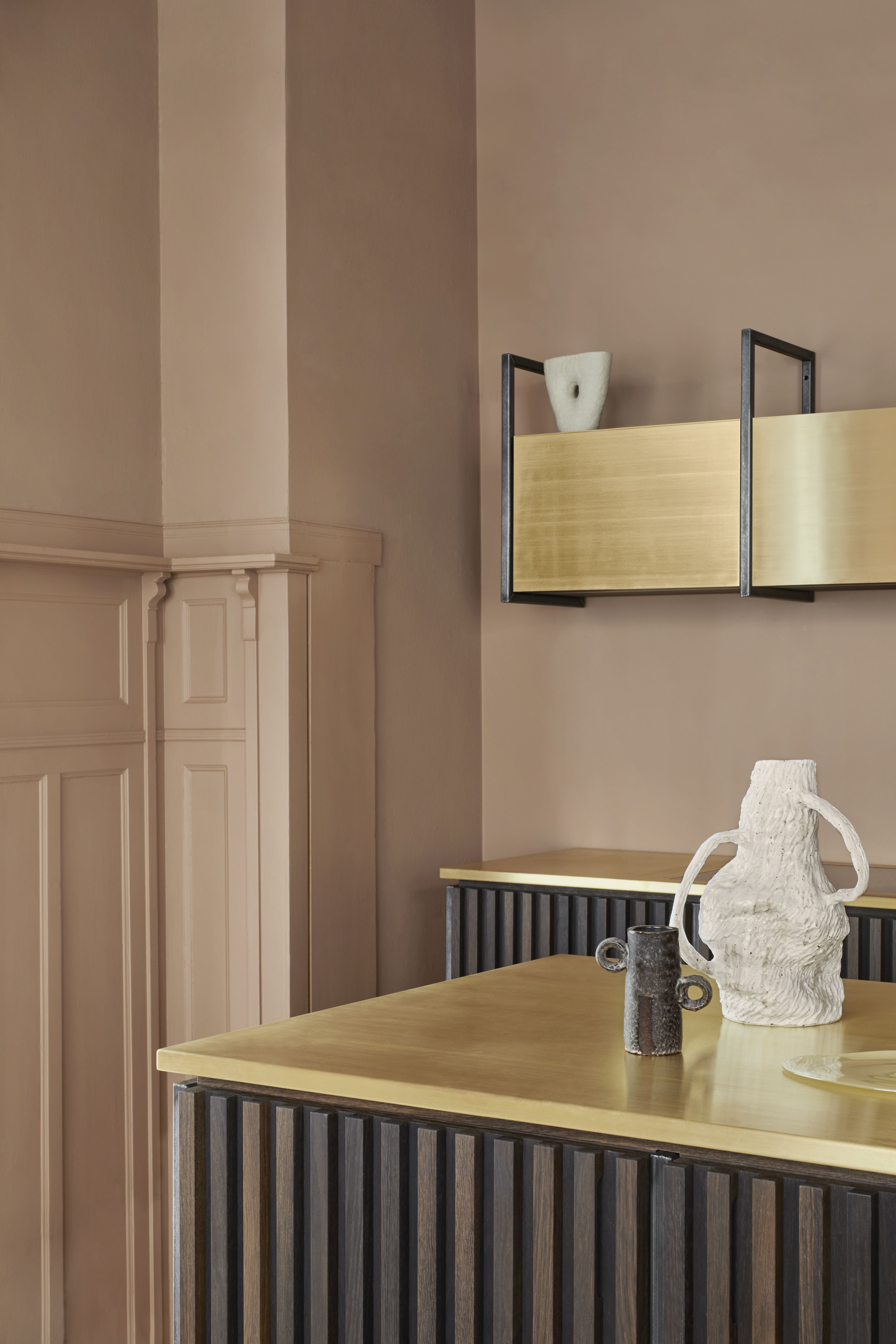 A kitchen with raw brass countertop, and wood island