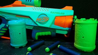 The Nerf Elite Jr. Rambler from the Rookie Pack with darts and targets, laid out against a dark background