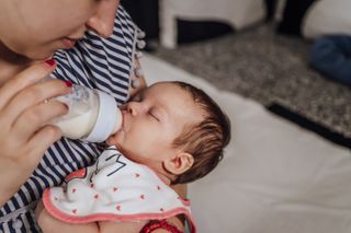 A woman bottle feeding a baby