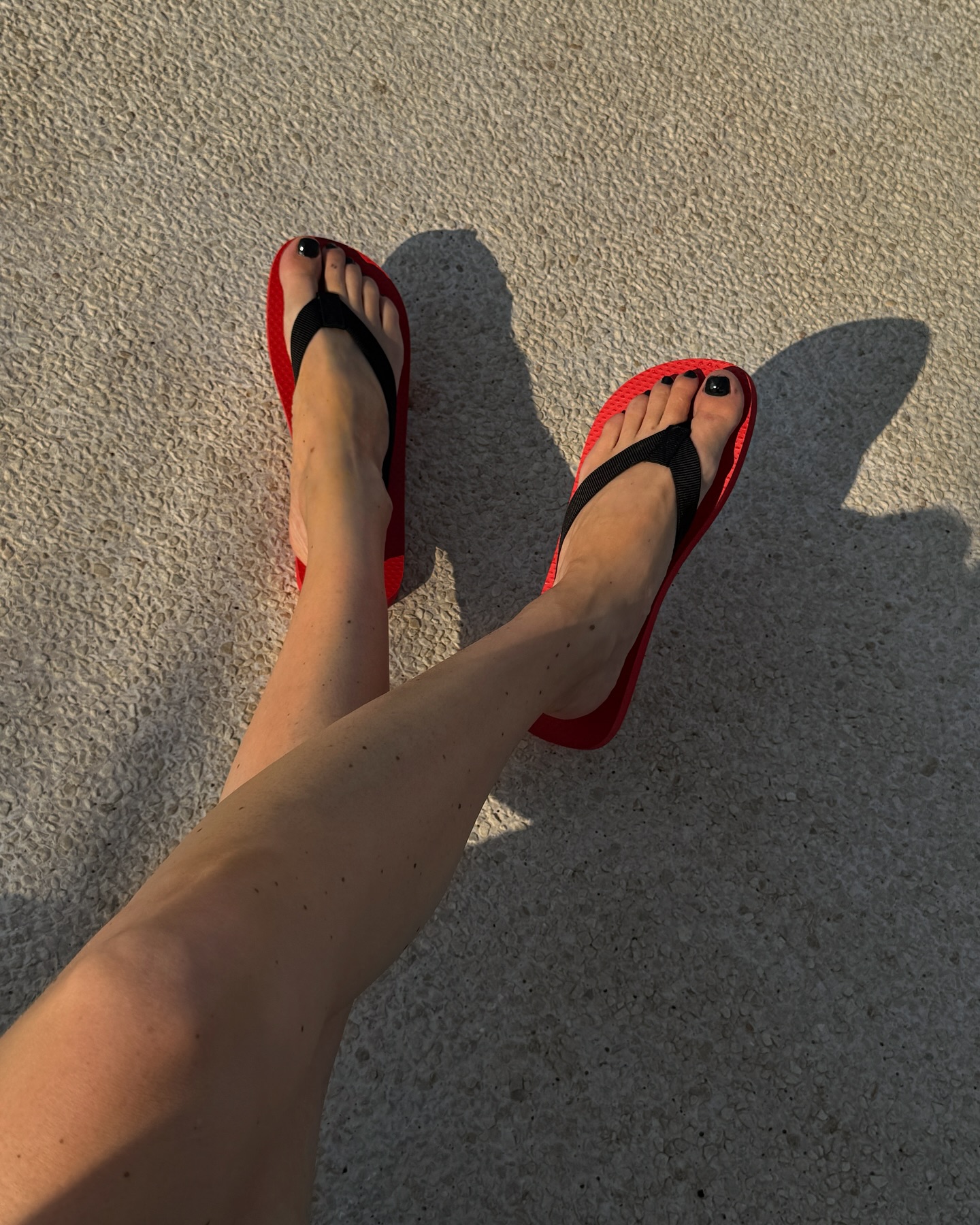 An image of @annabelrosendahl wearing red and black flip-flops.