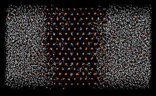 This computer simulation shows a uranium crystal (orange) forming in a liquid of carbon and oxygen nuclei (white).