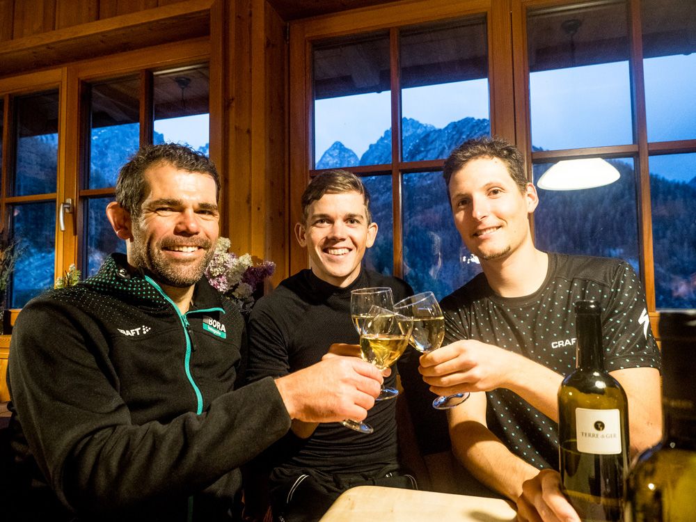 Team manager Ralph Denk enjoys a glass of wine with Gregor M&uuml;hlberger and Lukas P&ouml;stlberger