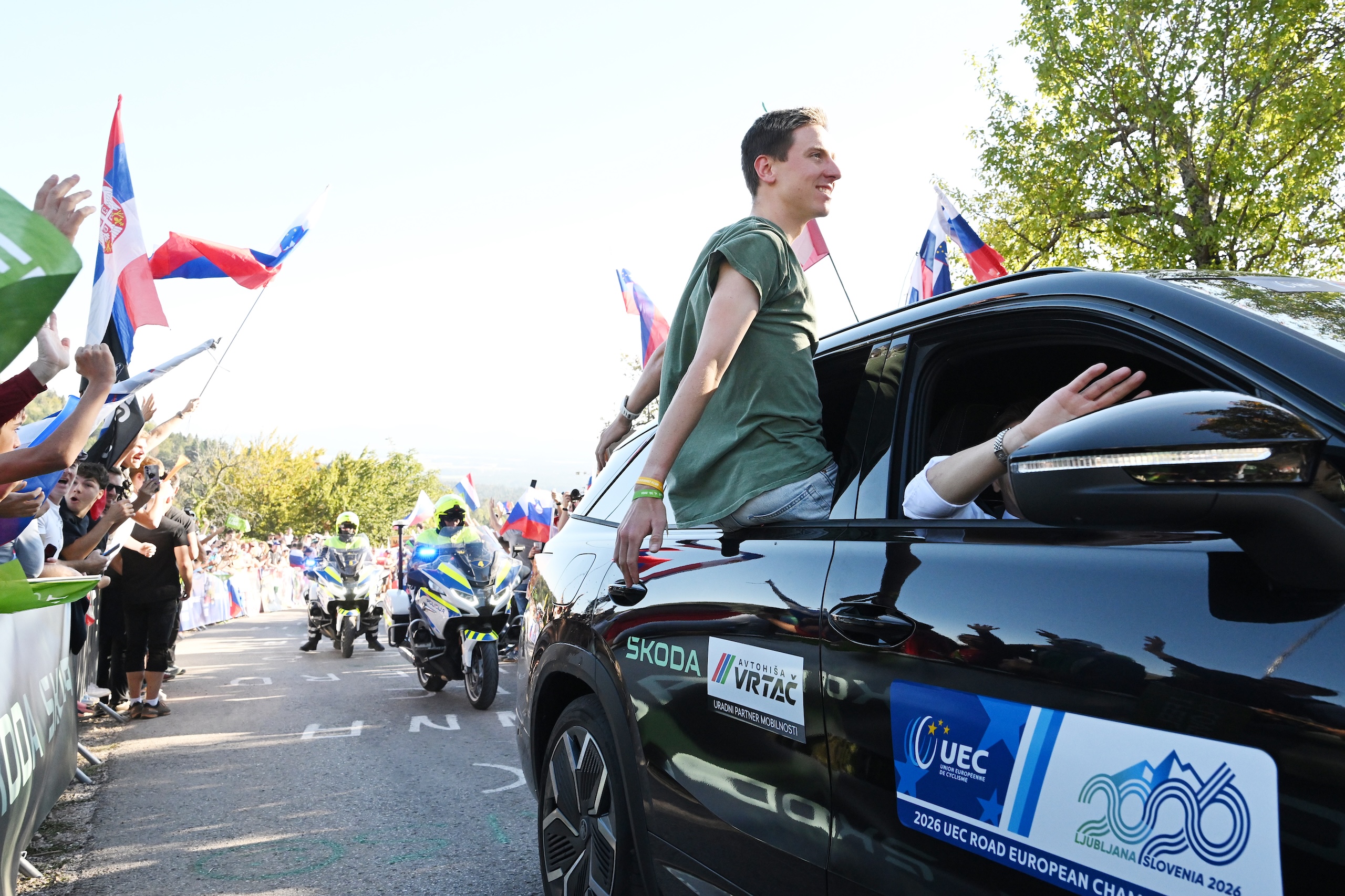 Slovenian superstar Tadej Pogačar waves to the fans on the side of the road at 2026 UEC European Road Championships