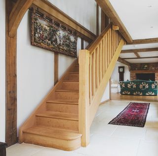 Wooden open stair case in white hall