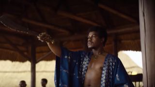 John Boyega raises his sword as King Ghezo in The Woman King