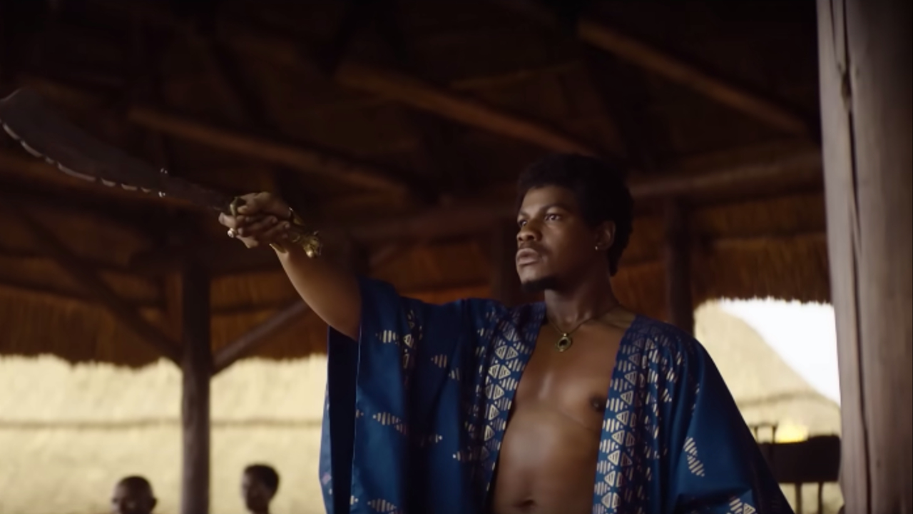 John Boyega levanta su espada como King Ghezo en The Woman King