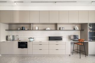 The Great Unit apartment by K.O.T. Architects - a beige kitchen wall unit.
