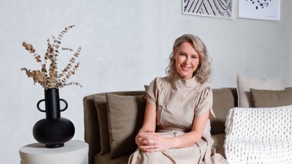 Kathrin Hamm, founder of Bearaby, seated on a couch next to a vase and artwork.