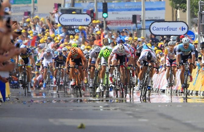 Cavendish on his way to the win, while in the distance a crash unfolds