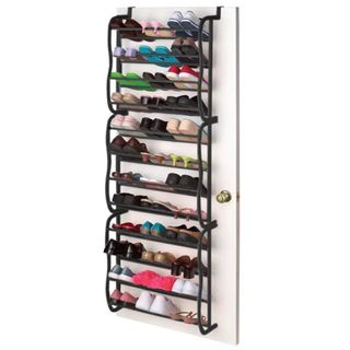 An over the door shoe organizer with black rails is full of shoes