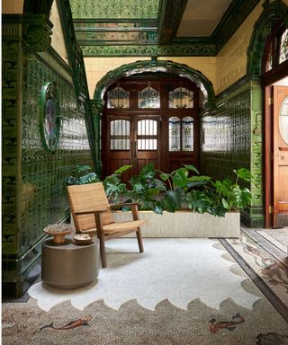 Green tiled hallway in art deco style with mosaic floor with fish and wave design