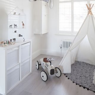 kids room with white walls and white tent