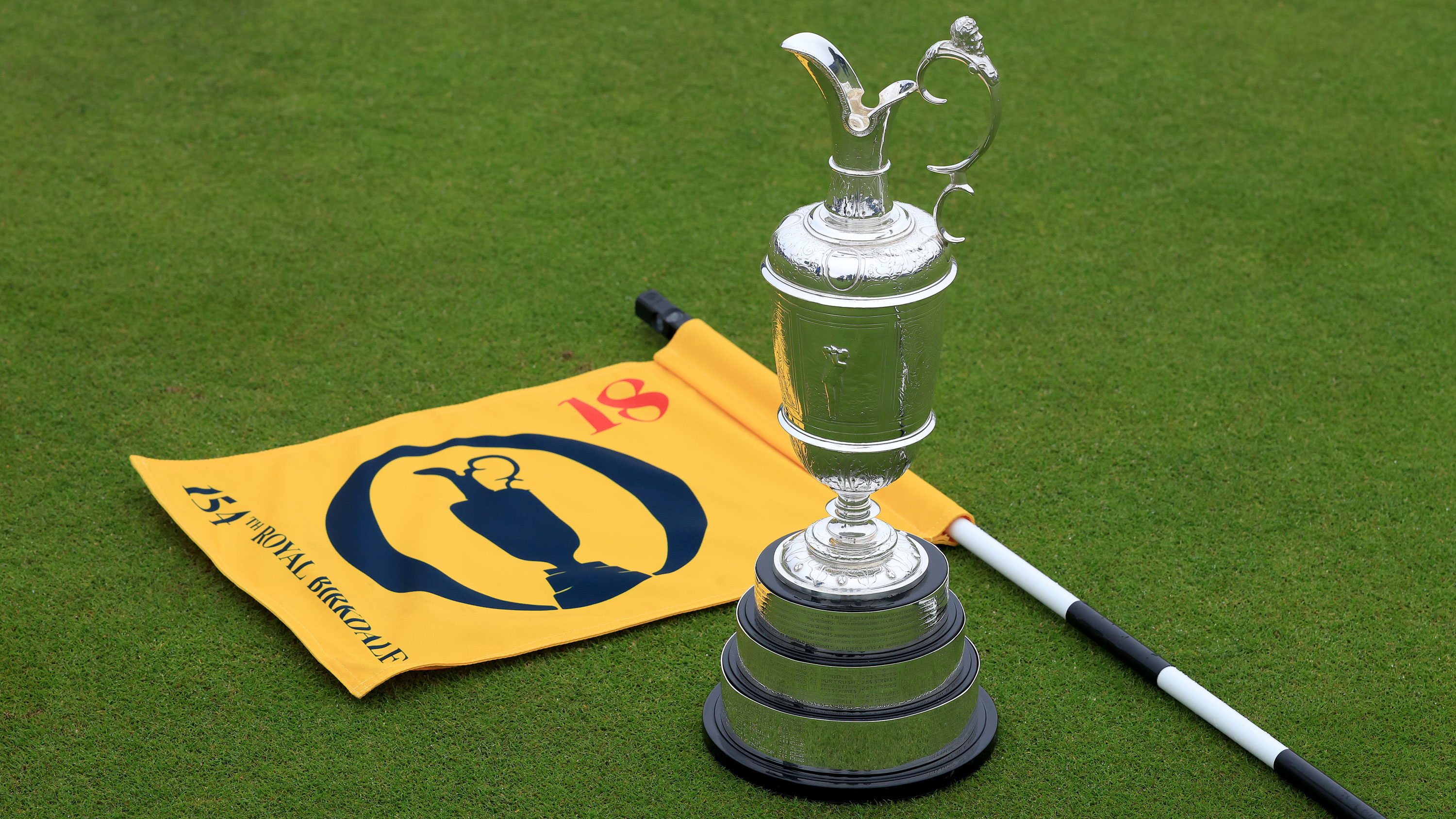 The Claret Jug on the 18th green at Royal Birkdale with the 18th flag lying on the floor next to it