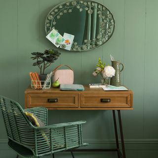 green coloured living room with oval shaped mirror and potted plant