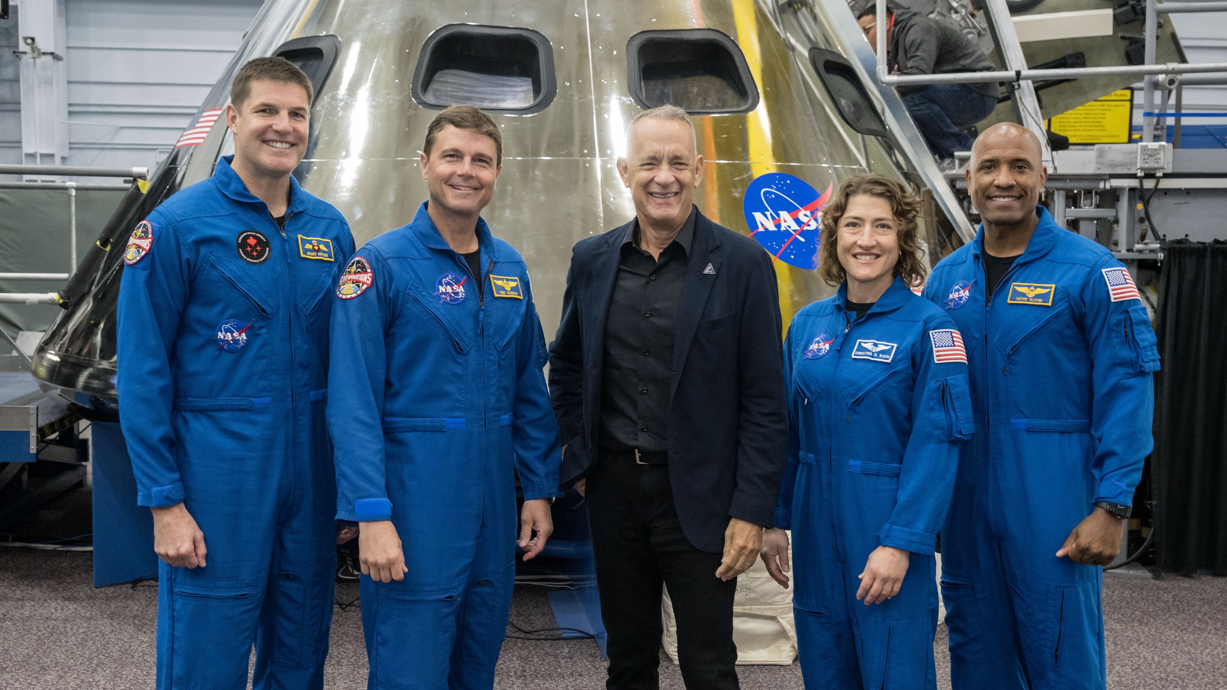 Actor and "Apollo 13" movie star Tom Hanks (center) with the Artemis 2 crew. The new moon astronauts include, from left, the Canadian Space Agency's Jeremy Hansen, NASA's Reid Wiseman, NASA's Christina Koch and NASA's Victor Glover. Behind them is a mockup of the Orion spacecraft for moon missions.