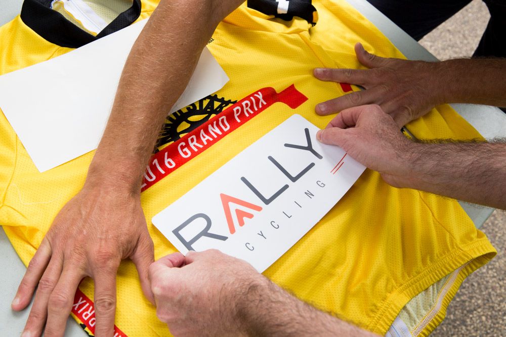 Applying the sponor's logo to Zirbe's yellow jersey.