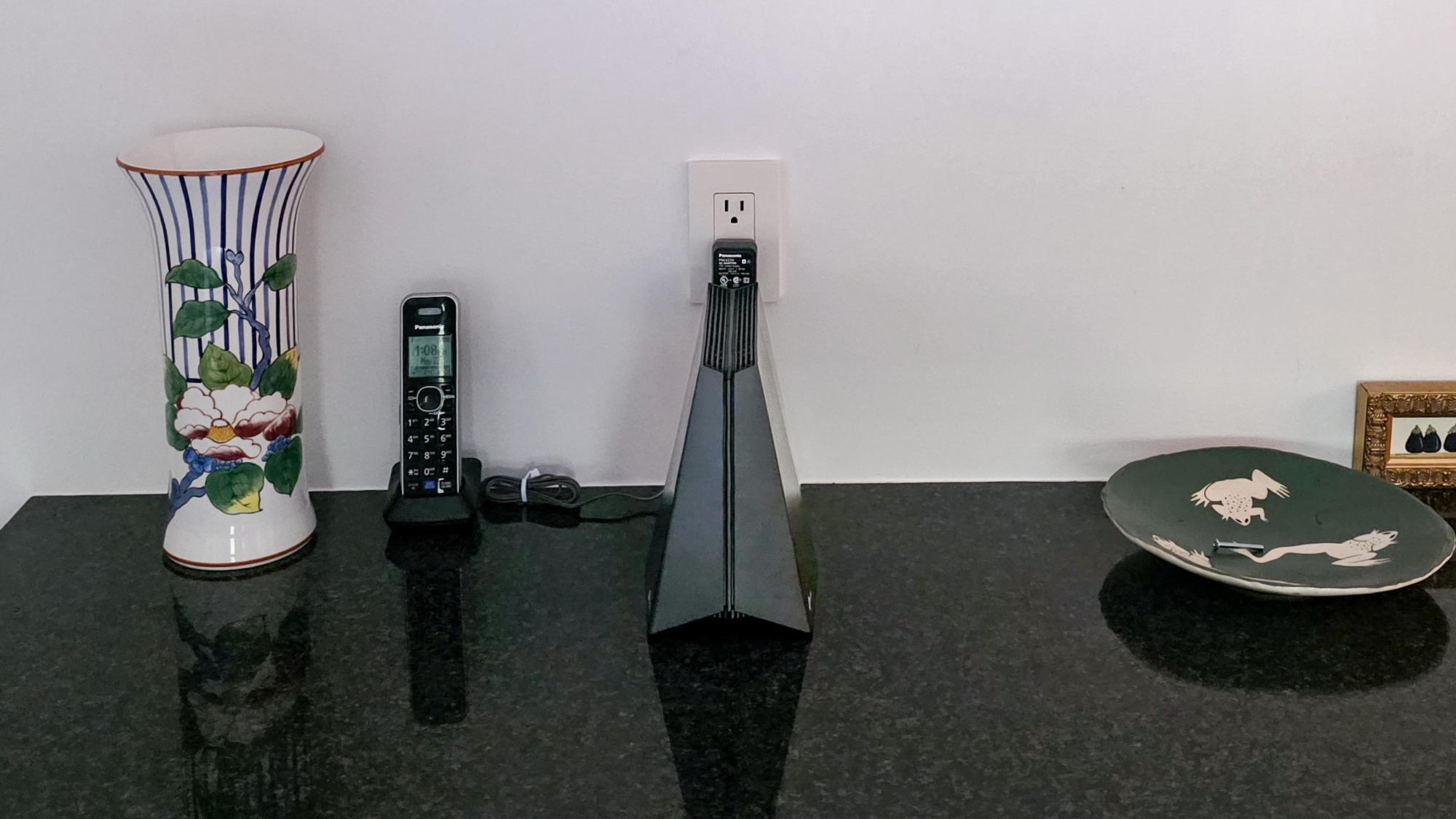 A TP-Link Archer GE650 router plugged in on a table