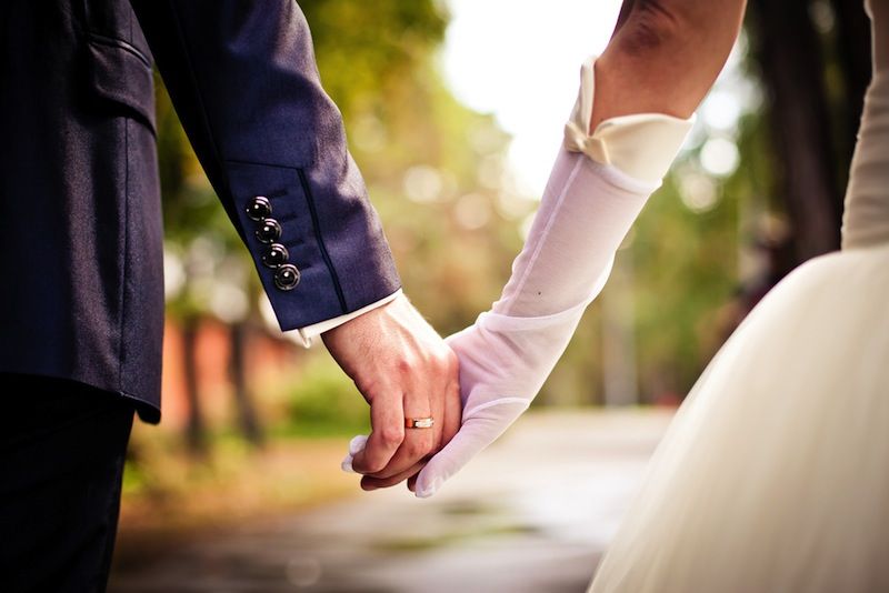 bride and groom hold hands