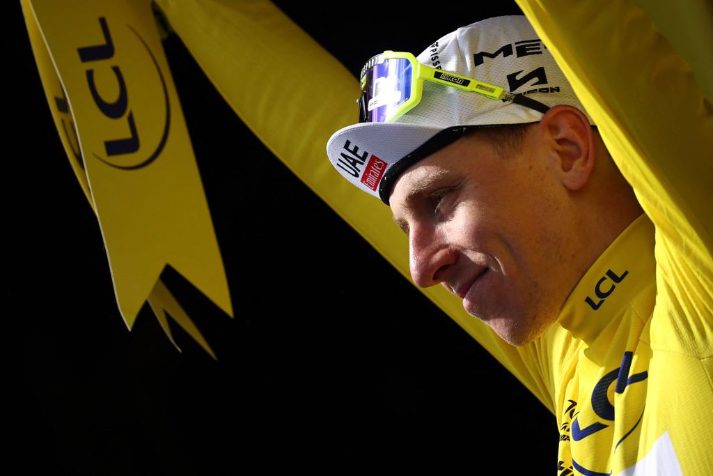 UAE Team Emirates team's Slovenian rider Tadej Pogacar celebrates on the podium with the overall leader's yellow jersey after the 15th stage of the 111th edition of the Tour de France cycling race, 197,7 km between Loudenvielle and Plateau de Beille, in the Pyrenees mountains, southwestern France, on July 14, 2024. (Photo by Anne-Christine POUJOULAT / AFP)