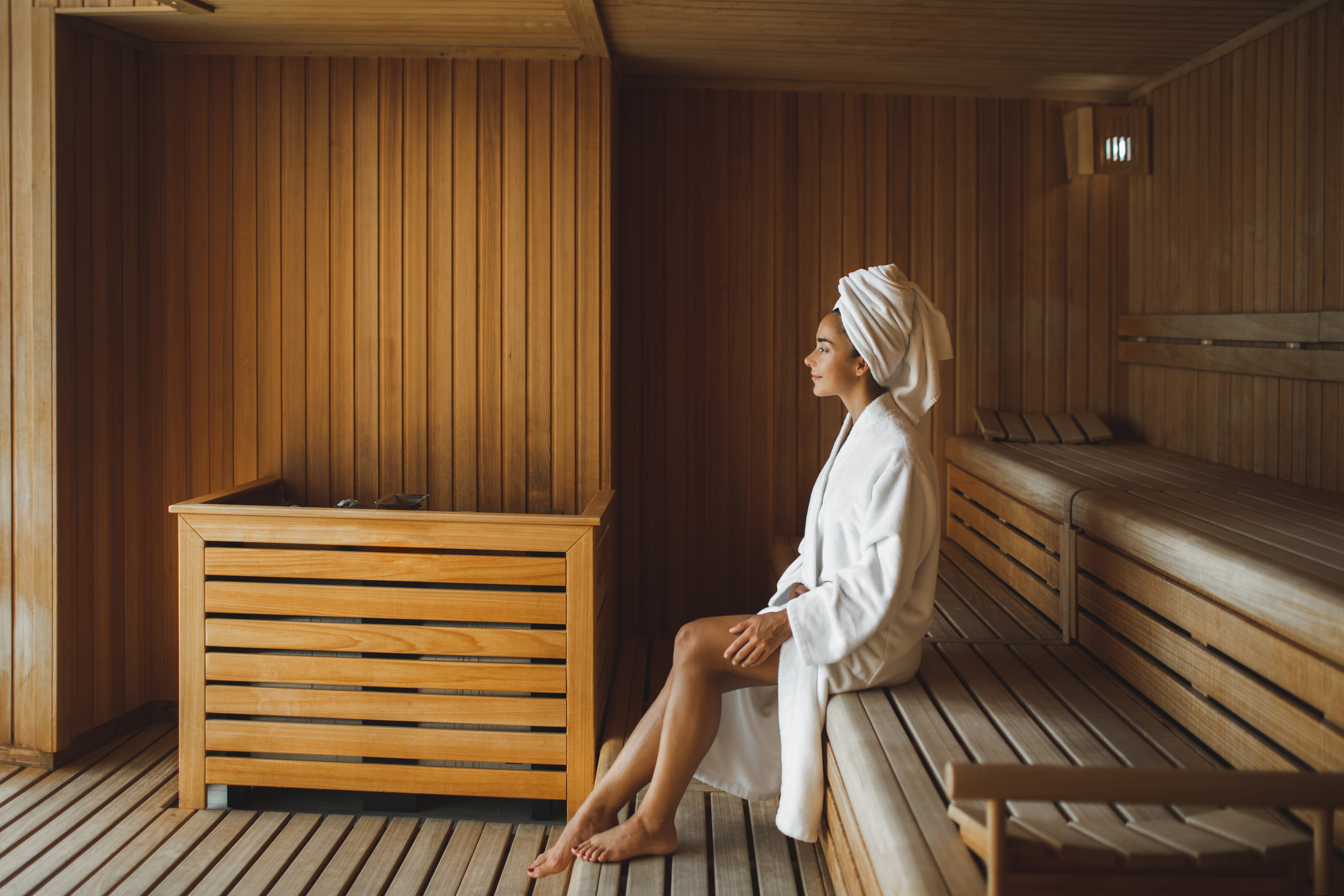 a woman in a white robe in a wooden sauna