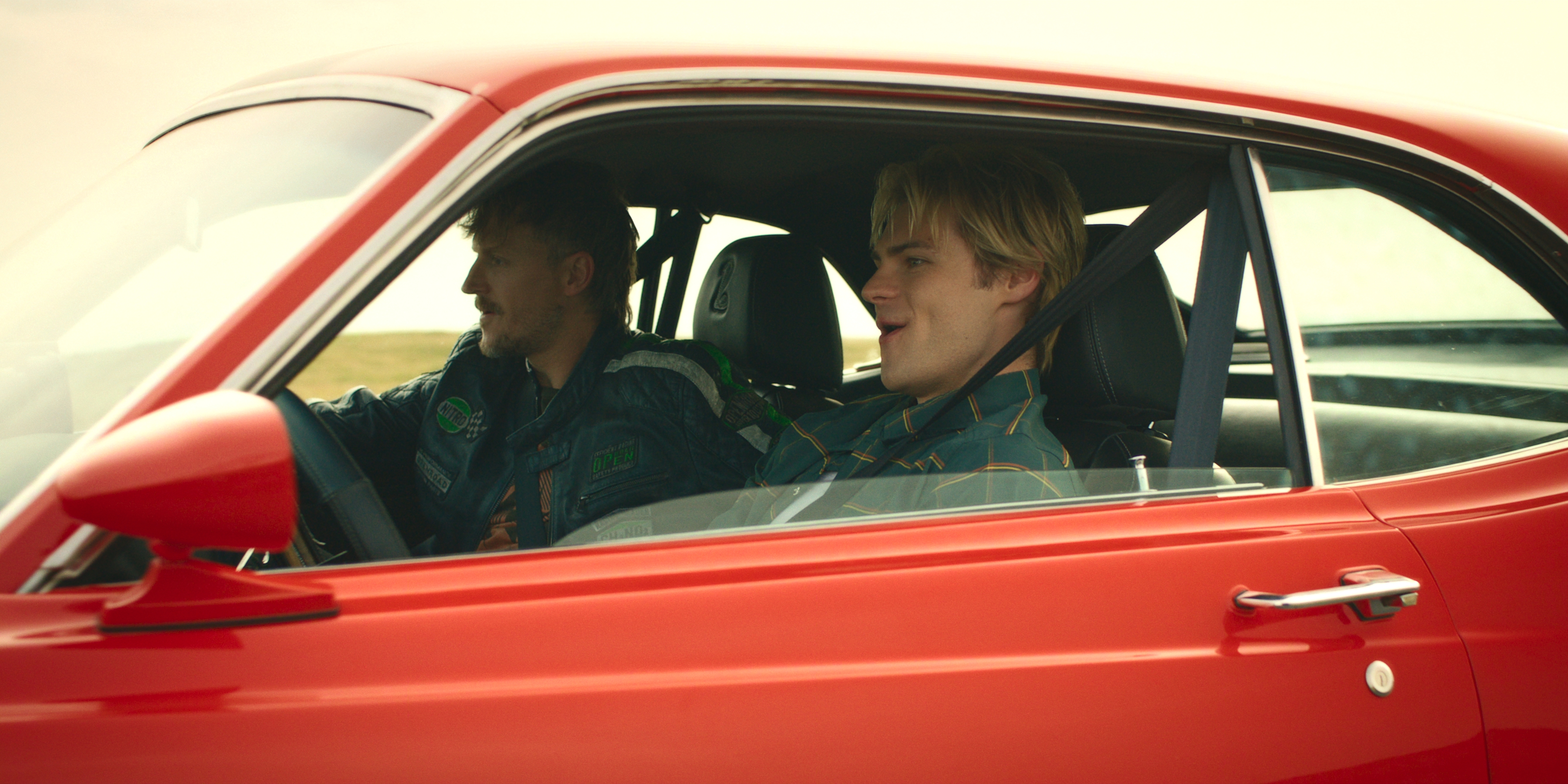 Chad Rook as Mac and Noah LaLonde as Cole Walter driving fast in a vintage red car in my life with the walter boys season 3