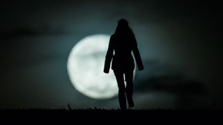 A woman hiking on the full moon