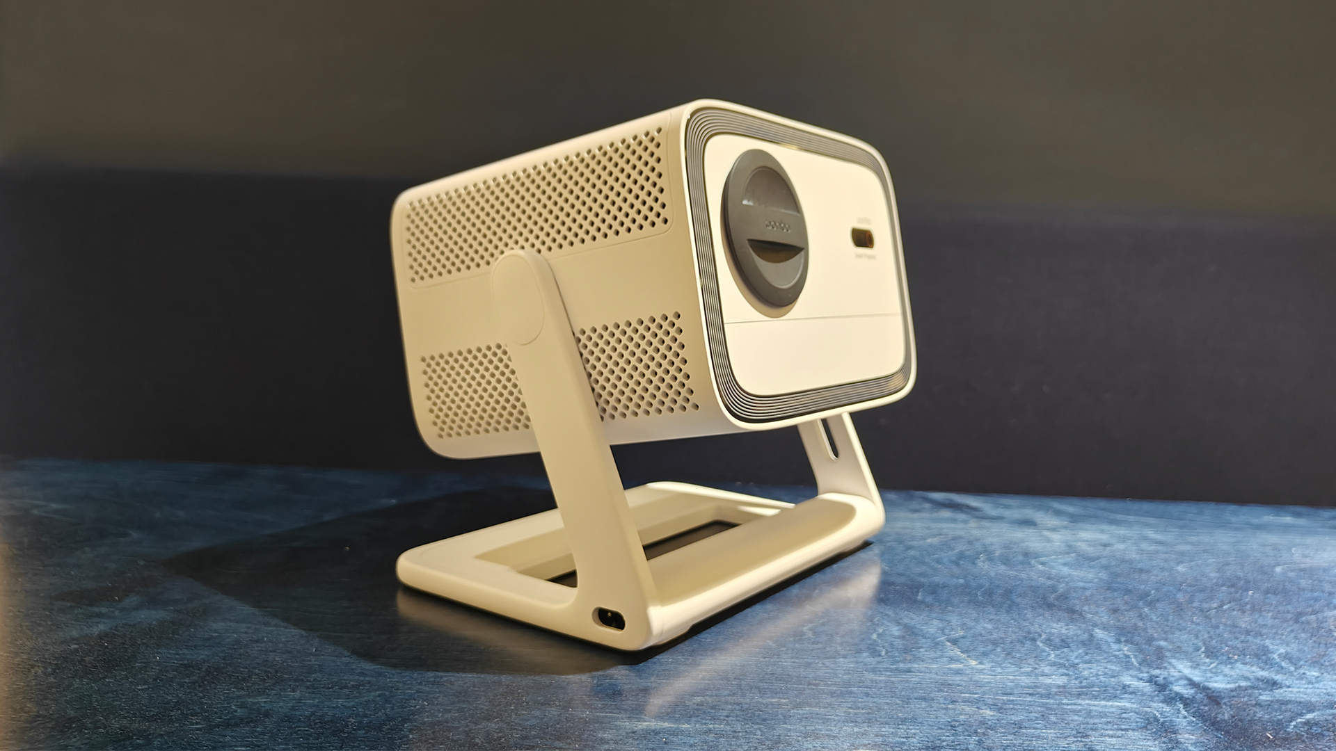 Wanbo Vali 1 home cinema projector on black wood surface, side angle