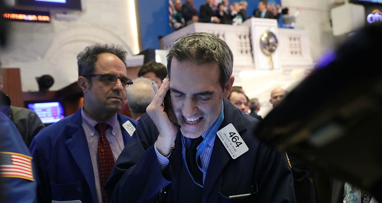 NYSE traders work the phones as the Dow Jones closes down 1,175.21 points