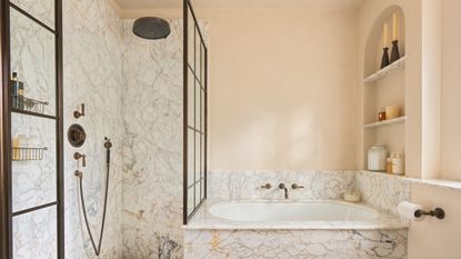 A bathroom with a shower, a plunge bath, and a built-in arched shelving niche