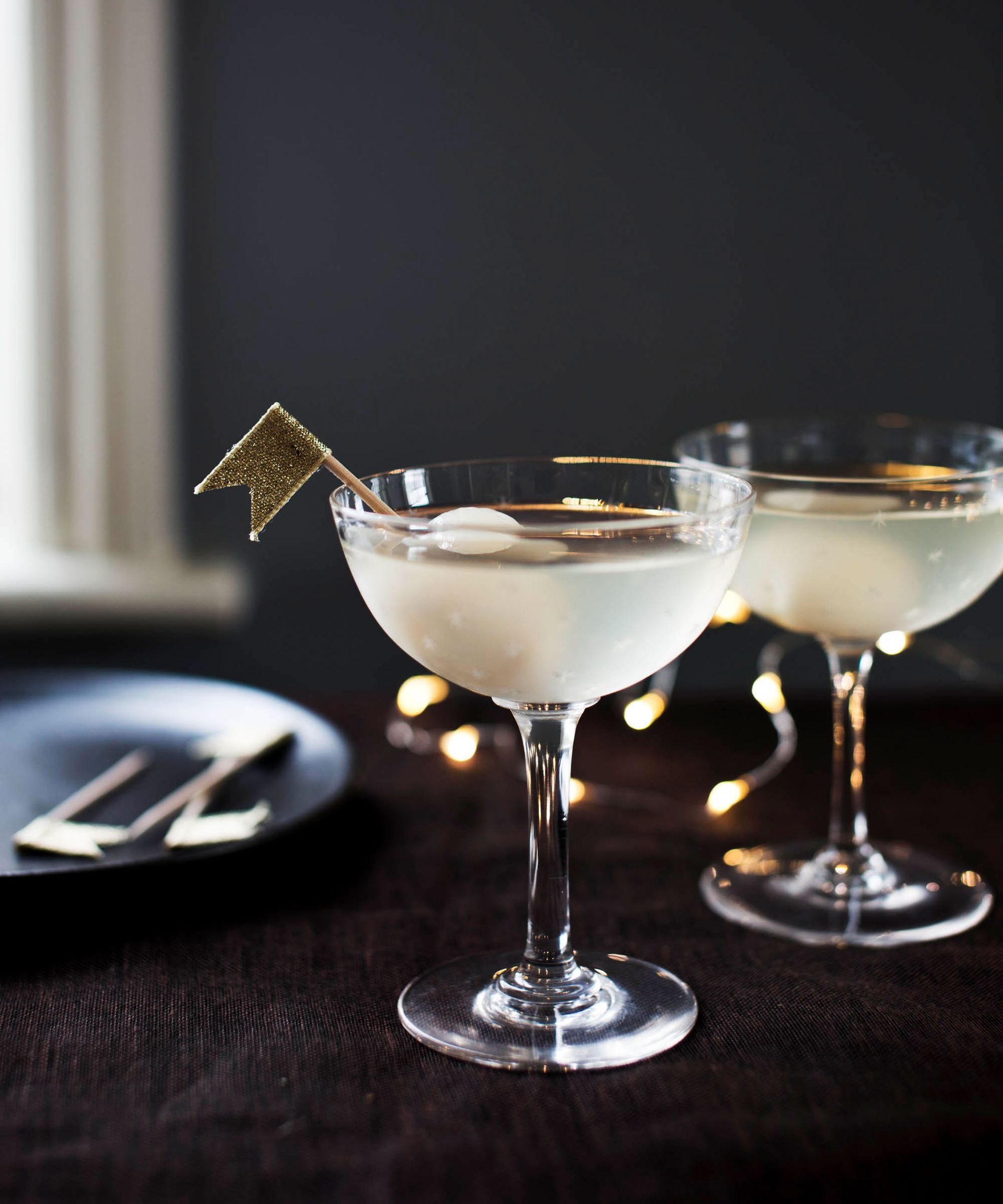 Two martini glasses with filled with drink, golden flag decoration