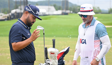 JJ Spaun and his caddie go through the golf bag during the US Open