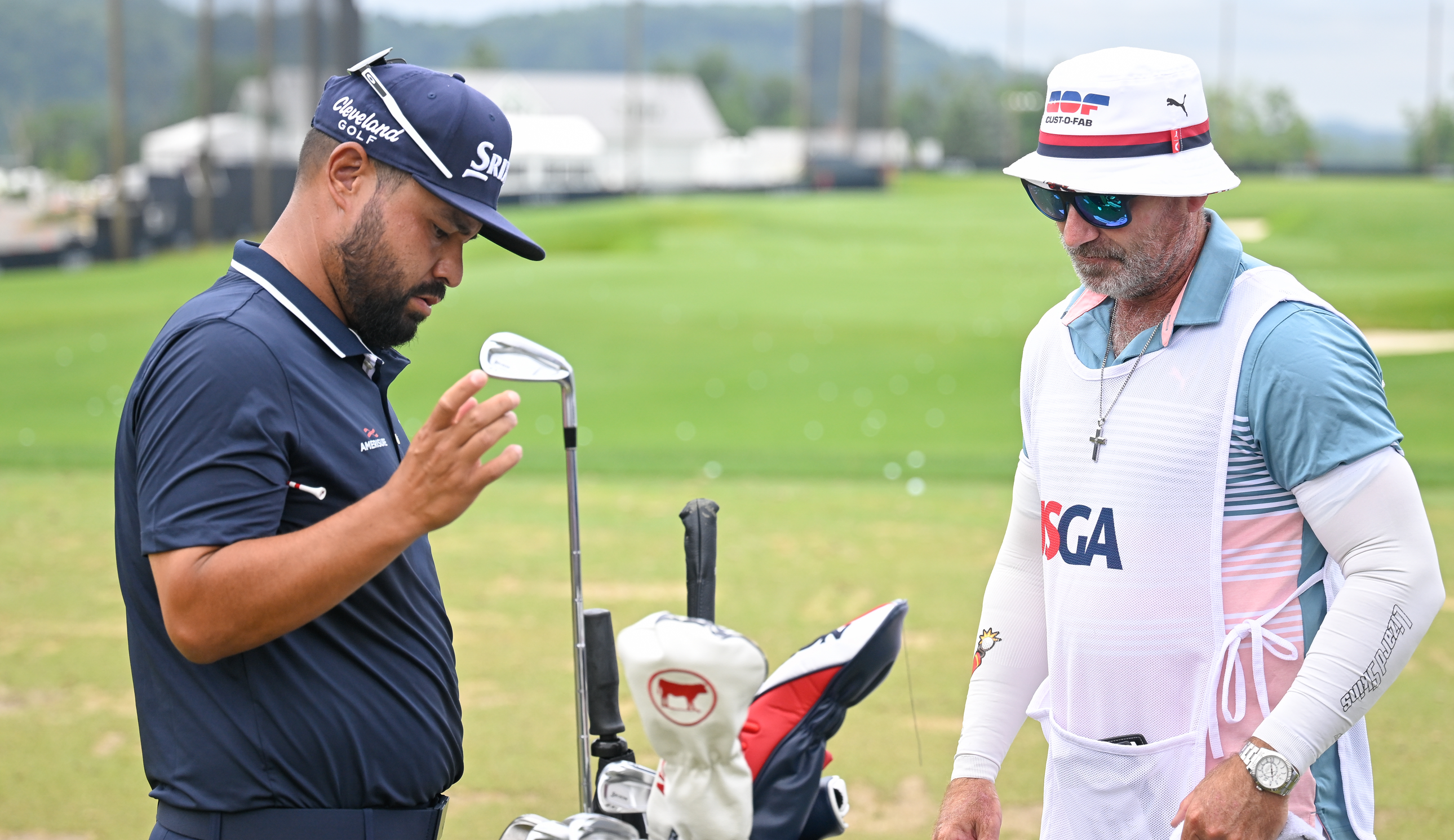 JJ Spaun and his caddie go through the golf bag during the US Open