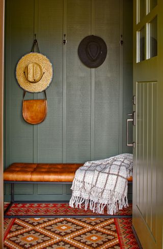 cabin entryway with gray walls and bench