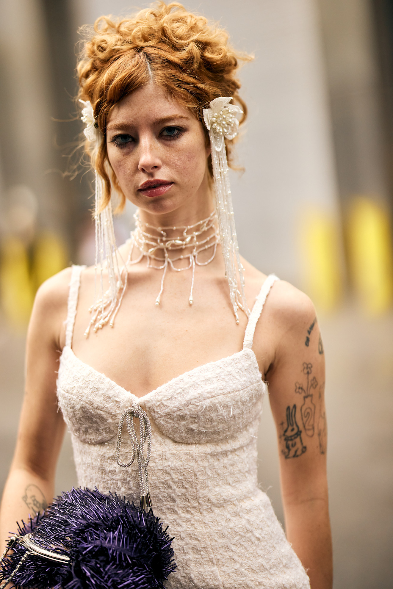 a woman with tattoos in a white dress with red hair and white flower accessories