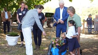 The Princess Royal is presented with flowers during a visit to the South African Riding School for Disabled Association (SARDA)