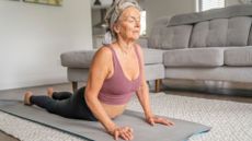 senior woman in cobra pose on a yoga mat