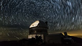The Hobby-Eberly Telescope against a backdrop of star trails in a long-exposure image.