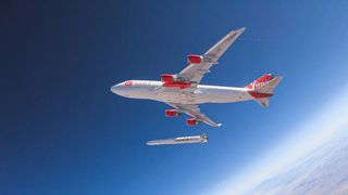 Cosmic Girl plane flying high above the ground below and releasing the LauncherOne rocket seen just below the aircraft.