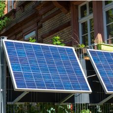 Plug-in solar panels mounted on a balcony railing outside a property