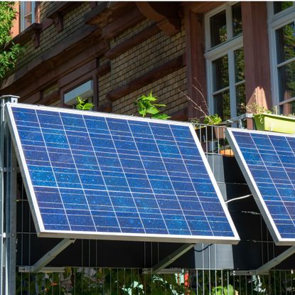 Plug-in solar panels mounted on a balcony railing outside a property