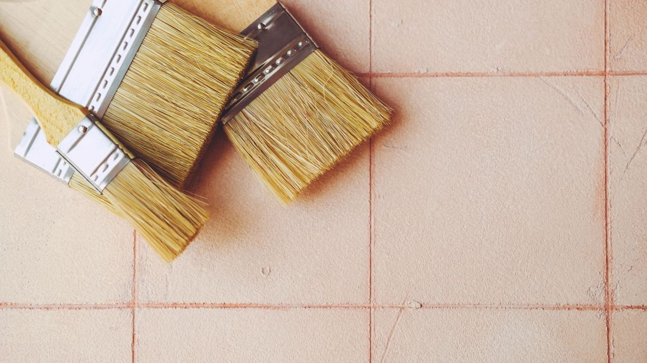 Some clean brushes laying on a pink tiled surface