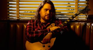 Wolfgang Van Halen pictured in warm lighting with his EVH signature semi-hollow