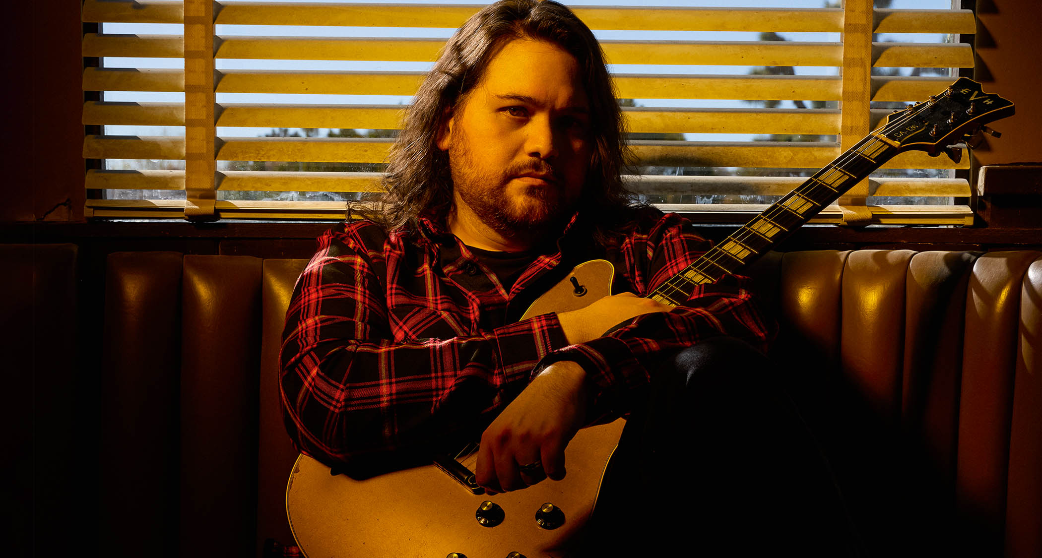 Wolfgang Van Halen pictured in warm lighting with his EVH signature semi-hollow