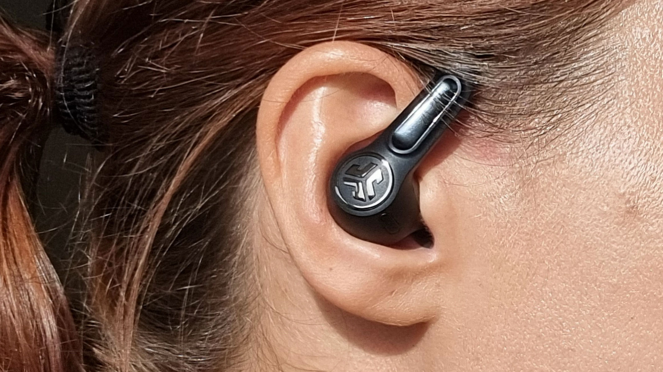 a close-up picture of our reviewer testing the JLab Epic Sport ANC 3 earbuds