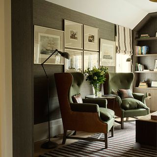 library and home office with wing back chairs and sleek gadget concealing oak bookcases